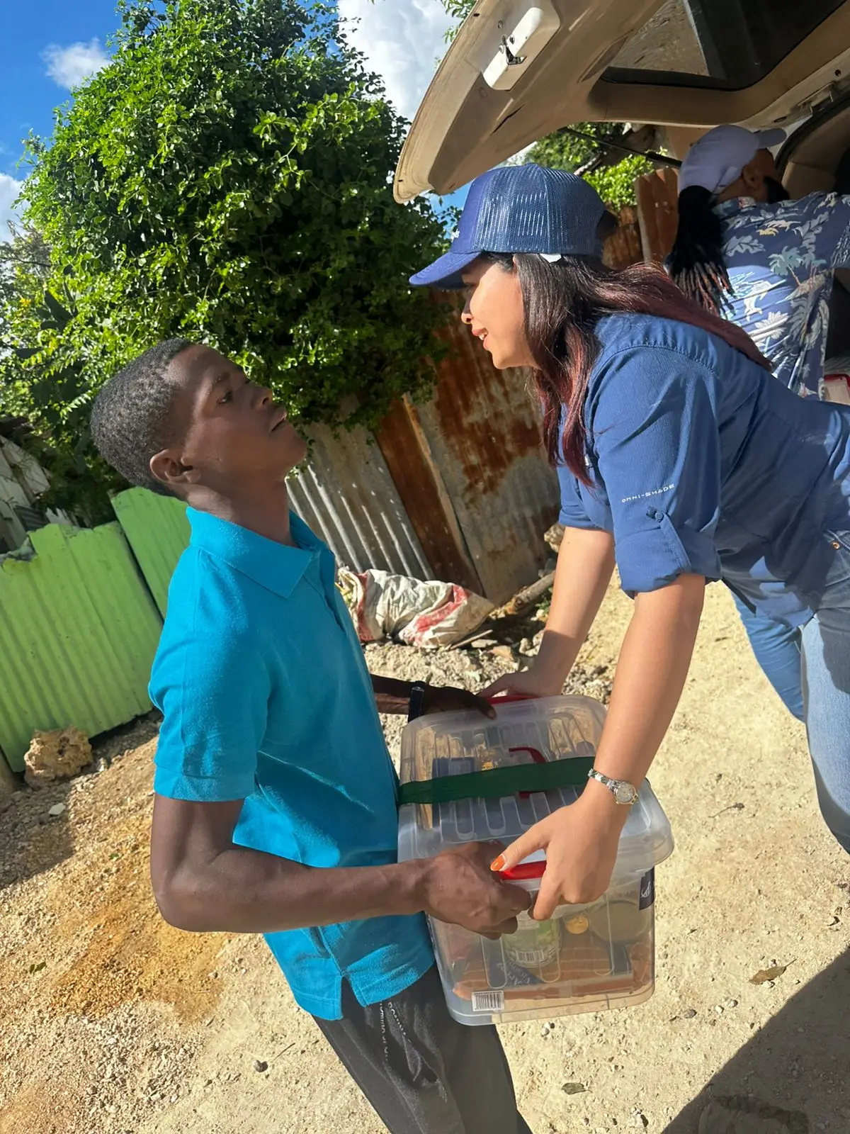 Agallas Cares volunteer delivering a food assistance package to a local resident
