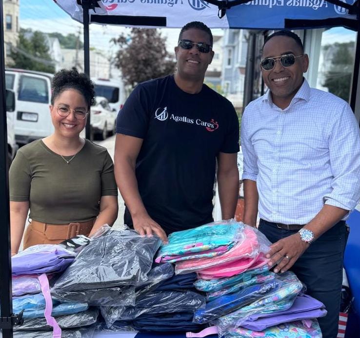 Agallas Cares volunteers with backpacks at a community school supply drive